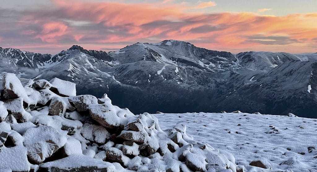 A snowy June sunrise seen from the saddle between "Cupid" Peak and Mount Sniktau.